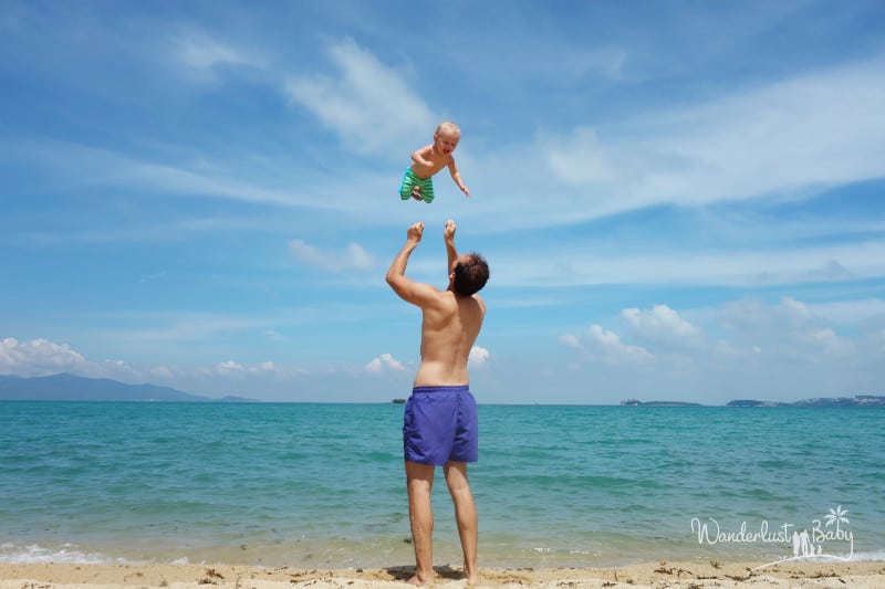Mann wirft Baby am Strand in die Luft